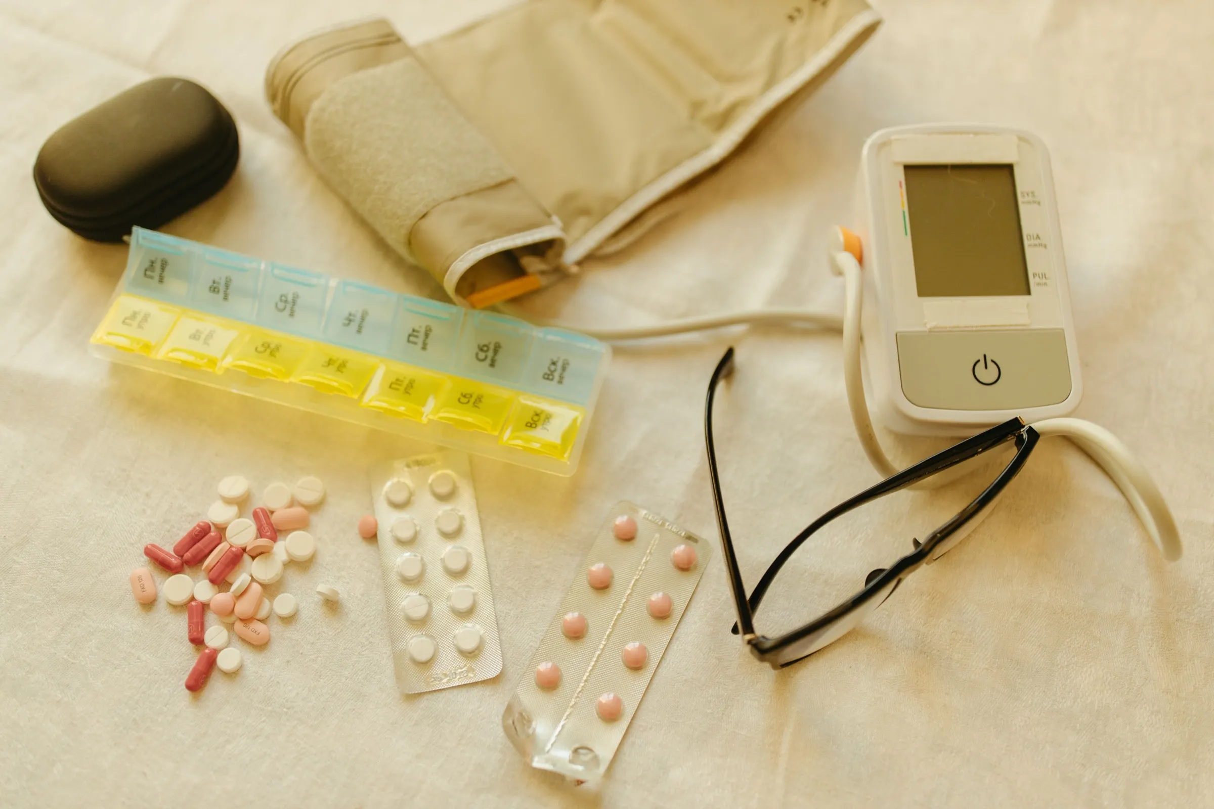 Medikamentenbox, Blutdruckmessgerät und Stethoskop auf einem Tisch